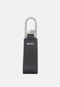 Crni kožni privjesak za ključeve s teksturiranom površinom, s metalnom srebrnom kopčom i ugraviranim logom "BOSS" s prednje strane.