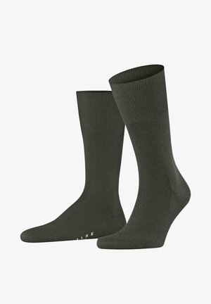 Dark green crew socks made of smooth material, featuring a ribbed cuff and a seamless toe design. Subtle branding on the sole.