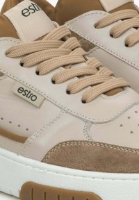 Tenisky vyrobené z béžové kůže a semiše s hnědými akcenty. Rovné tkané tkaničky, perforované detaily a bílá gumová podešev.