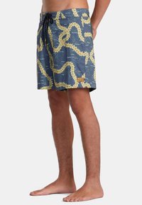 Vattentåliga badshorts i marinblått med ett gult blommönster och krämfärgade detaljer. Har en elastisk midja med dragsko.