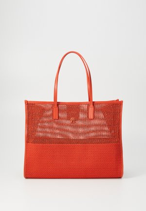 Sac en toile rouge en mailles avec des accents en cuir lisse, forme rectangulaire, doubles poignées et un panneau inférieur texturé. Possède un détail de logo minimal.