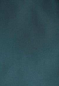 Teksturowana tkanina w głębokim odcieniu morskim, z delikatnym, jednolitym wzorem splotu. Gładkie wykończenie z lekko miękkim wyglądem.