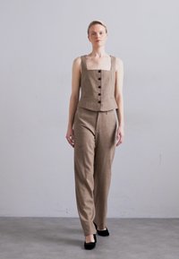 Brown tailored outfit with a square neckline, button front, and wide-leg trousers. Fabric appears textured with a soft finish.