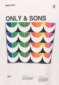 Camiseta blanca con un diseño gráfico audaz que presenta semicírculos multicolores en verde, azul, naranja y rosa sobre un fondo negro.