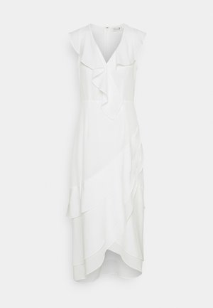 Robe sans manches blanche avec un décolleté en V et des détails en volants. Présente des panneaux de tissu superposés et une taille ajustée. Fermeture à glissière au dos.