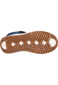 Gummisåle med et fleksibelt, tekstureret design. Har en brun bund med diamantmønstre og en hvid accent ved hælen.