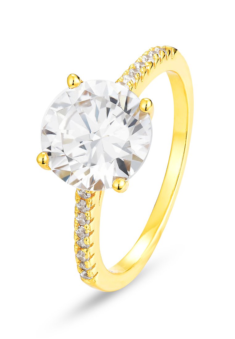 Anello in oro con una grande pietra tonda e trasparente, incastonata con quattro griffe, e una fascia decorata con piccole pietre trasparenti su un lato.