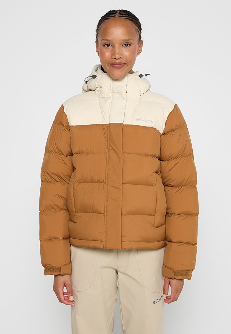 Brązowa i kremowa kurtka puchowa z pikowanym designem, regulowanym kapturem i zamkiem błyskawicznym z przodu. Posiada logo na lewej piersi oraz luźny krój.
