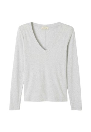 Šviesiai pilkas ilgomis rankovėmis marškinėliai su V formos iškirpte. Pagaminti iš švelnios medžiagos, turi laisvą siluetą ir minimalistinius siuvimo akcentus.
