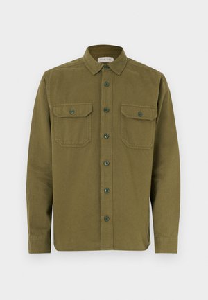 Cămașă verde măsliniu din bumbac, cu nasturi în față, două buzunare frontale și mâneci lungi. Prezintă un guler ascuțit și tiv rotund.