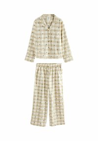 Beige rutigt pyjamas-set med en knäppbar topp med ficka och byxor med elastisk midja prydda med gröna trä-mönster. Mjuk tygkänsla.