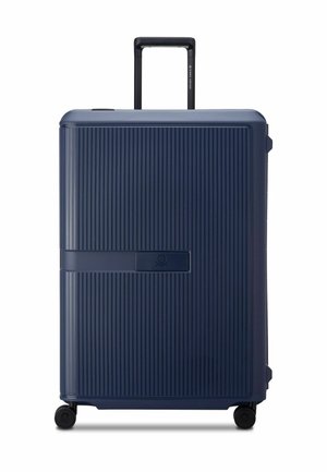 Harde koffer in donkerblauw, met een verticale ribbelstructuur, stevige handgreep en vier soepel rollende wielen voor gemakkelijke mobiliteit.