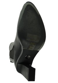 Musta korkokenkä, jossa on sileä nahkapinta, neliön muotoinen varvas, teksturoitu kumipohja ja matala lohkokanta. Logo näkyvissä pohjassa.