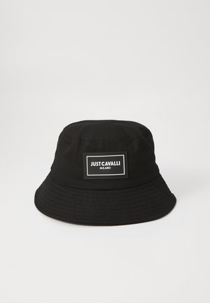 Svart bøttehatt laget av stoff med bred, rund skjerm. Har en rektangulær logo-patch med hvit tekst foran.