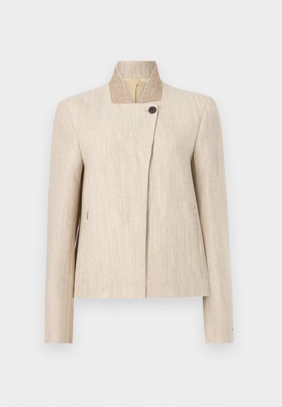 Beige hørkvindeblazer med opretstående krave, enkelt sort knaplukning nær halsudskæringen og lange ærmer.