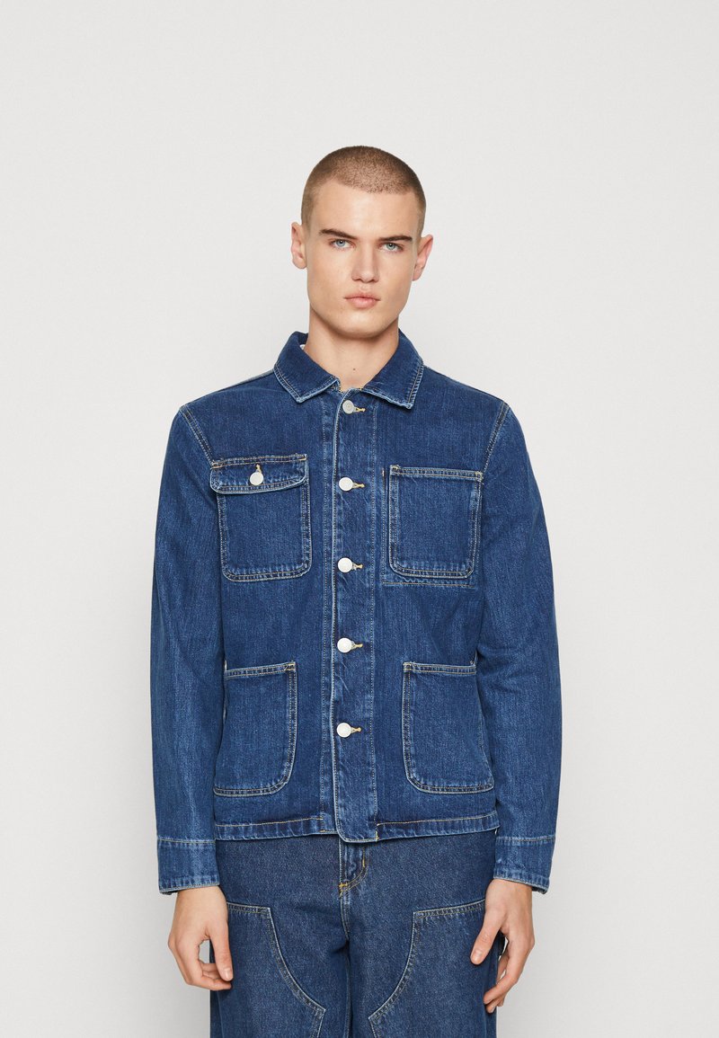 Giacca di jeans blu con colletto, chiusura anteriore con bottoni e quattro tasche. Il design presenta cuciture in evidenza e una superficie liscia.