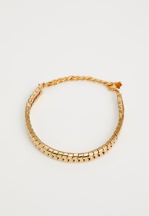 Zlatý tónovaný kovový náhrdelník s čtvercovými články a zkrouceným řetězem. Obsahuje bezpečné zapínání a hladký, lesklý povrch.