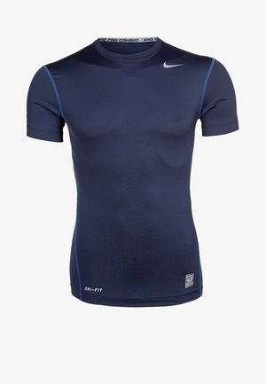 Camiseta de compresión Nike Pro Combat Dri-FIT de color azul marino con manga corta, logotipo Swoosh gris cerca del hombro y costuras azules que contrastan.