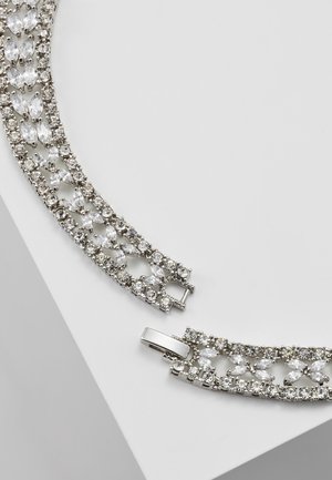 Bracelet en argent avec des pierres précieuses claires de forme marquise et ronde dans un motif en chaîne, présenté détaché sur une surface blanche.