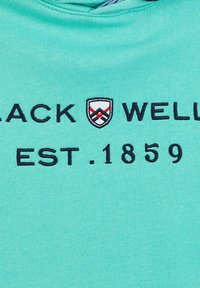 T-shirt en coton teal clair avec un logo noir brodé comportant un blason et le texte "BLACK WELL" et "EST. 1859". Texture lisse.