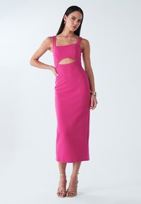 Robe midi rose cintrée avec encolure carrée et détail découpé. Tissu lisse et extensible. Associée à des talons métalliques à brides.