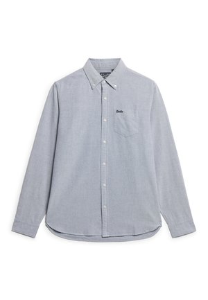 Camisa abotonada de color azul claro, con manga larga, textura sutil, un bolsillo en el pecho y un logo bordado en la parte superior izquierda.