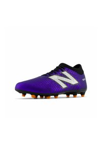 Bota de fútbol morada con superficie texturizada, acentos negros y tacos naranjas. Presenta un logo plateado distintivo y un diseño aerodinámico.