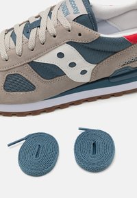 Grå og teal sneakers med suede- og mesh-paneler, hvit logo-detalj og brun gummisåle. Inkluderer to blå snøringer.