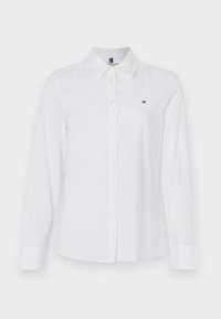 Chemise blanche à manches longues avec boutons, en coton, dotée d'un col classique, d'un logo subtil sur la poitrine et de boutons jaunes.