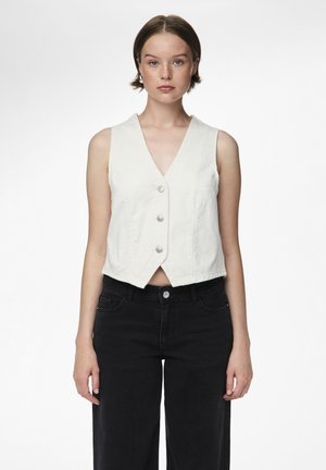 Light beige sleeveless vest with a V-neck, featuring five buttons down the front, paired with high-waisted black denim pants.