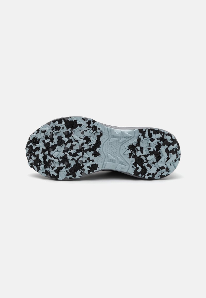 Semelle de chaussure de sport noire avec un motif de semelle texturé. La semelle intermédiaire est bleu clair, avec un design mixte à motifs et unis.