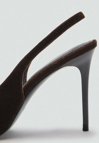 Scarpa con tacco alto in suede marrone, slingback, con punta affusolata e elegante tacco a stiletto nero. Presenta un design con ritaglio vicino alla cinghia alla caviglia.
