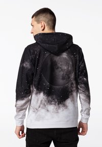 Mikina s kapucí s potiskem galaxie v černé a šedé barvě, s velkým grafickým motivem měsíce na zadní straně, vyrobená z měkké tkaniny, s pružnými manžetami.