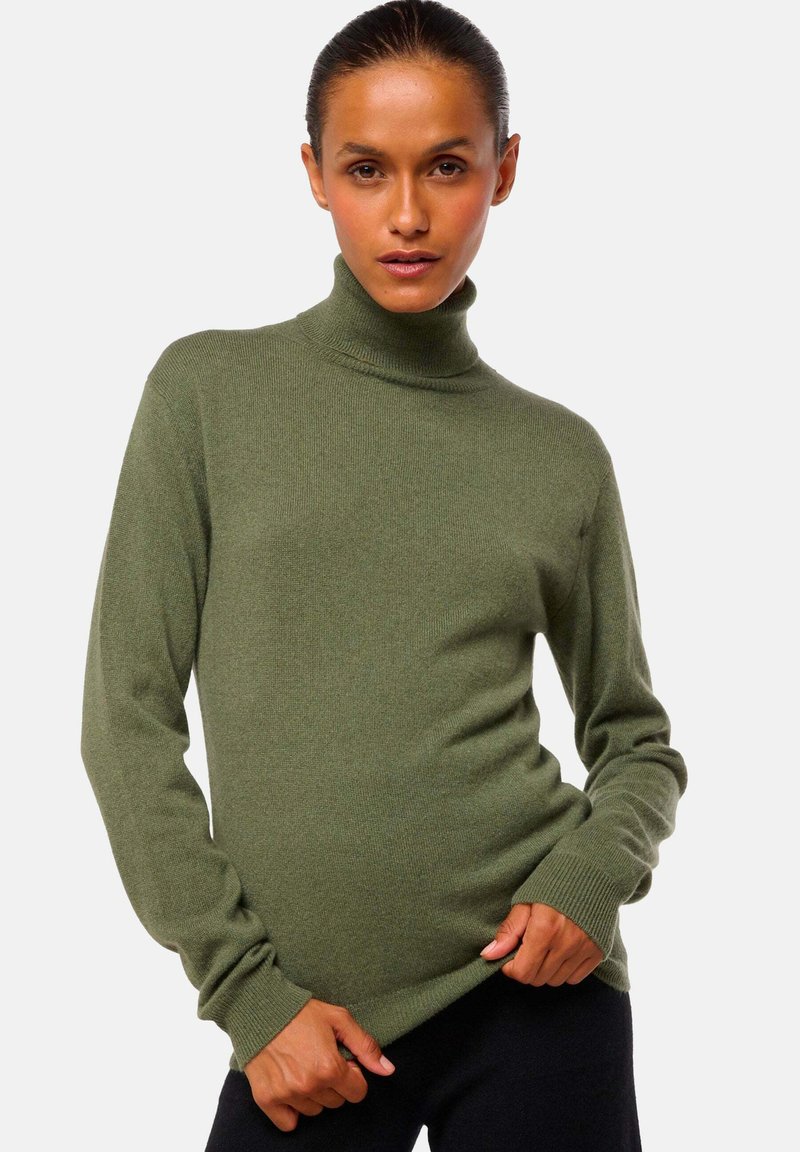 Pull à col roulé vert olive en texture tricot douce. Doté de manches longues et d'une silhouette ajustée avec des poignets et un ourlet côtelés.