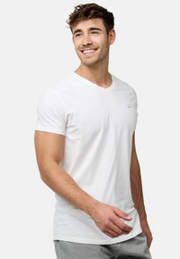 Hvid bomulds V-hals t-shirt med korte ærmer, med et lille logo på venstre bryst. Glat tekstur og tætsiddende design.