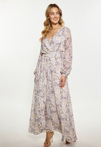 Florale maxi-jurk met een wikkelontwerp, v-hals, lange mouwen en een elastische taille. Kleuren zijn onder andere lichtlavendel, geel en groene accenten.