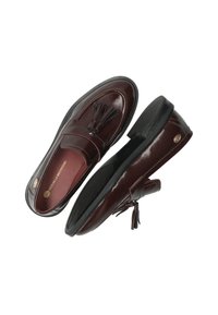 Mocasines de cuero burdeos con un acabado brillante, acentos de borlas, detalles de costura y una suela de goma negra.