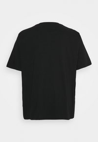 Camiseta negra de manga corta con cuello redondo. La tela es suave, con un corte recto y sin patrones ni acentos visibles.