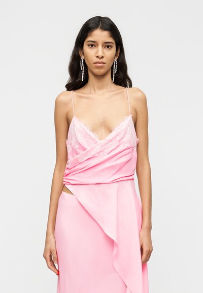Robe rose avec détails en dentelle, comprenant des bretelles fines, un design croisé et une fente latérale. Texture lisse avec une silhouette fluide.
