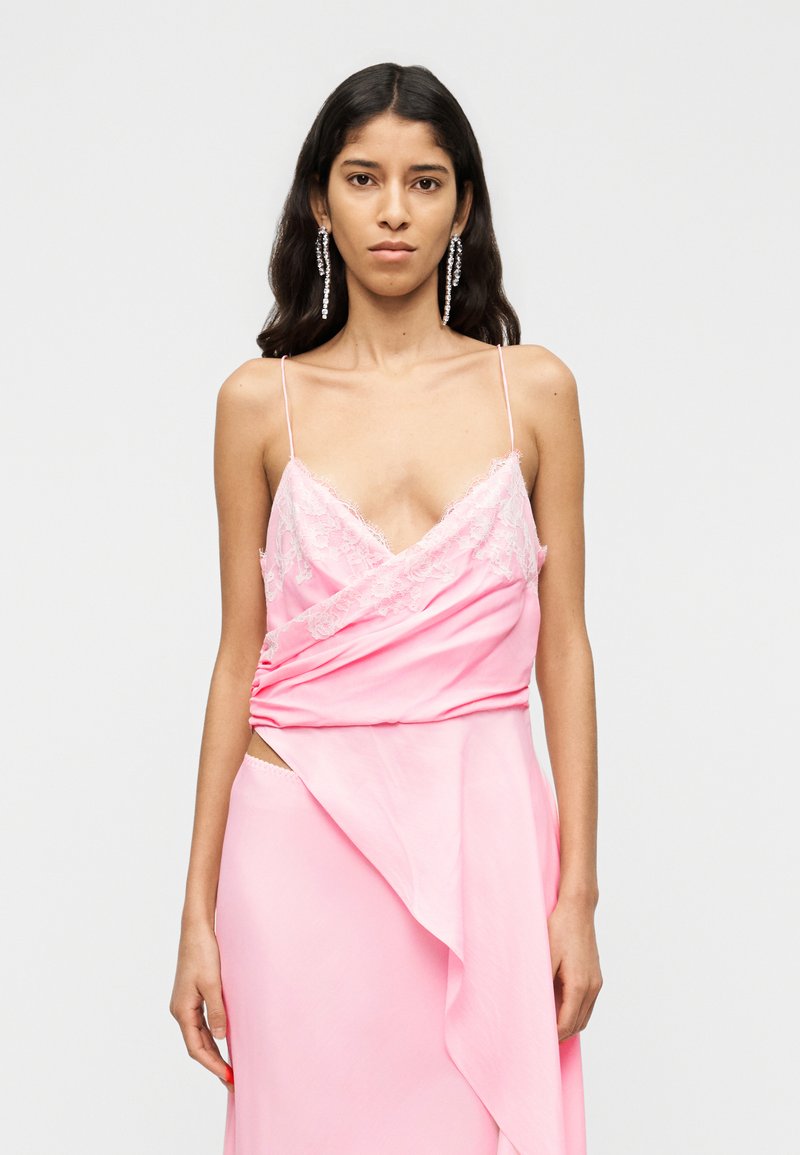 Ροζ φόρεμα με λεπτομέρειες δαντέλας, με λεπτές τιράντες, σχέδιο με περιτύλιγμα και πλευρικό άνοιγμα. Λείο ύφασμα με ρέουσα σιλουέτα.
