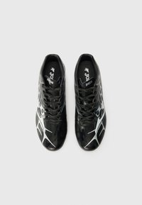 Scarpe sportive nere con un design elegante caratterizzate da un motivo testurizzato e dettagli bianchi. Realizzate in materiale sintetico con lacci neri.