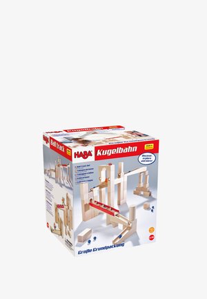 Ein Kugelbahn-Set aus Holz mit hellen Holzteilen, roten und blauen Elementen sowie verschiedenen Formen zum Bauen. Die Verpackung enthält eine Spielanleitung.