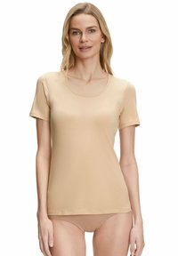 Beżowa koszulka z krótkim rękawem o okrągłym dekolcie, wykonana z miękkiej, elastycznej tkaniny, charakteryzująca się dopasowanym krojem i minimalną ilością szwów dla komfortu.