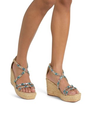 Sandali con zeppa e suola in juta intrecciata, caratterizzati da cinturini incrociati decorati con perline blu e iridescenti, design open-toe e fibbia alla caviglia.