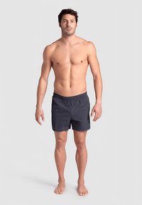 Donkerblauwe zwemshort met een elastische tailleband en een klein logodetail. Lichtgewicht stof, lengte boven de knie, en platte naden.