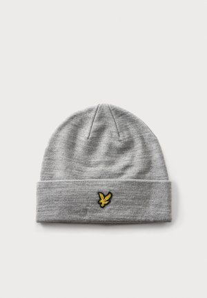 Bonnet tricoté gris clair avec un revers plié et un petit logo oiseau jaune au centre avant du revers.