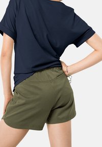 Námořnická modrá tričko s volným střihem a ohrnutými rukávy, spárované s olivově zelenými šortkami s elastickým pasem a jemnou texturou.