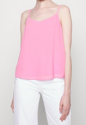 Débardeur sans manches rose en tissu léger, avec un décolleté en V et un ourlet droit, associé à un pantalon blanc.