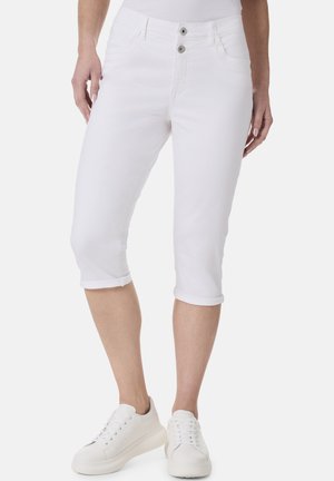 Weiße Caprihosen aus Denim, mit einer doppelten Knopfversch closure, umgeschlagenen Säumen und Seitentaschen. Kombiniert mit weißen Sneakers.