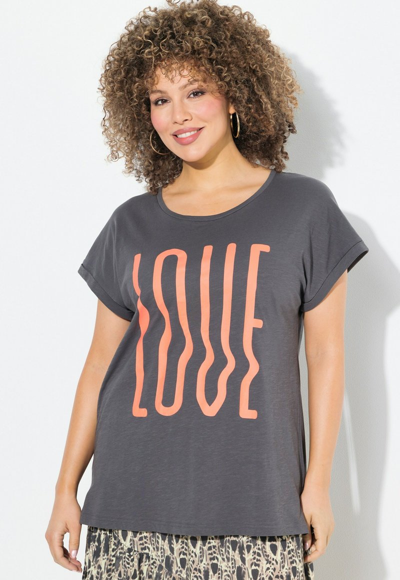 Camiseta gris de manga corta con un gran texto en coral que dice "LOVE". Textura suave, corte relajado con un cuello redondo, combinada con una falda estampada.